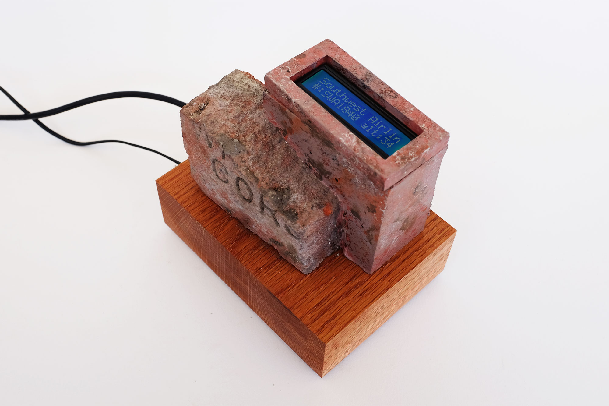 sculpture of a brick, augmented screen in painted cast cement